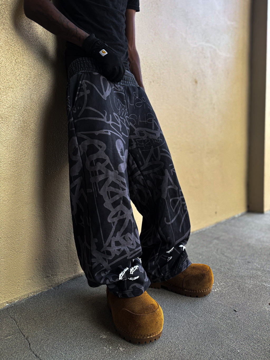 Black Vandalizm Sweats featuring oversized fit and stylish graphic print, paired with cozy footwear.