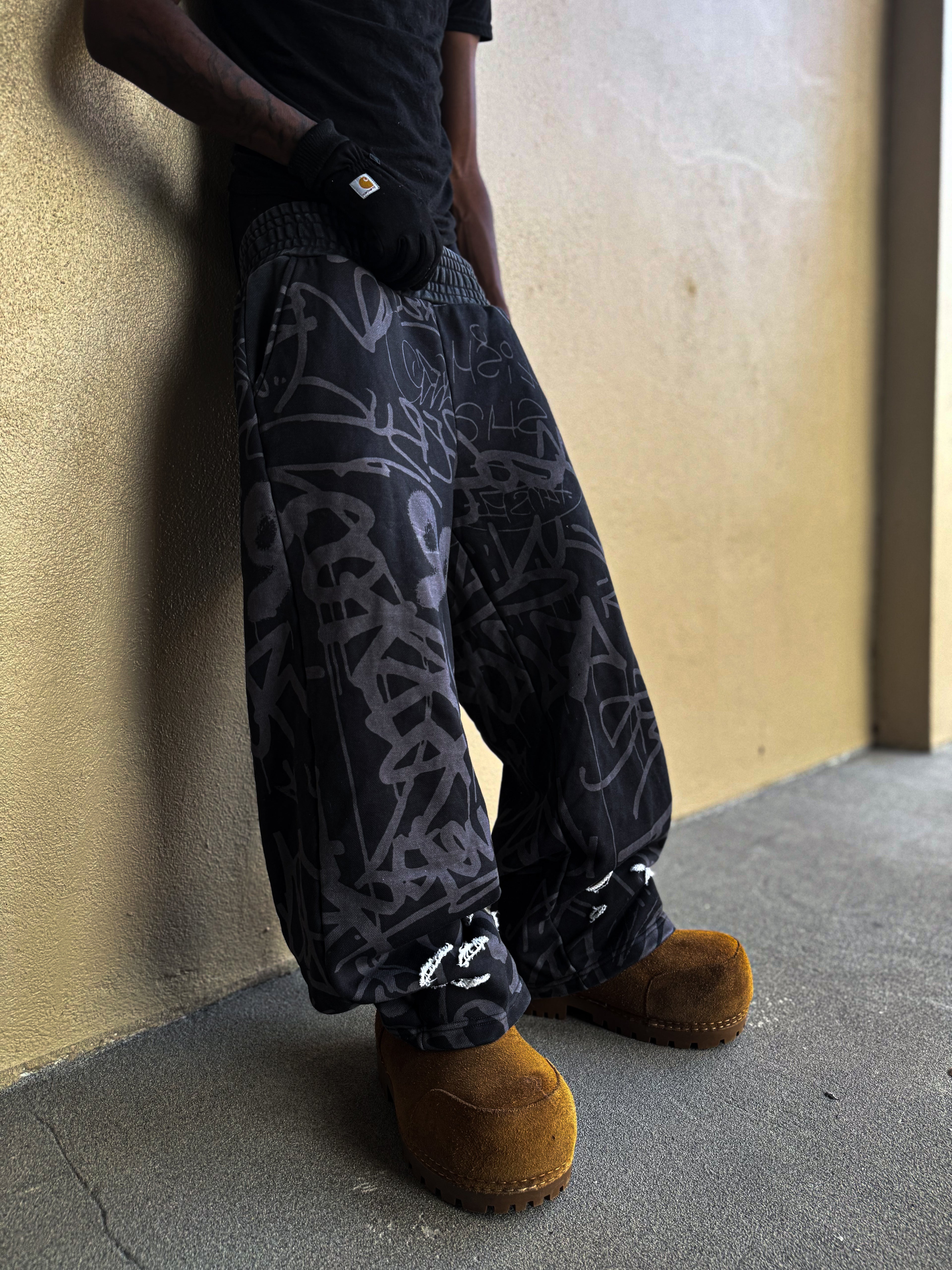 Black Vandalizm Sweats featuring oversized fit and stylish graphic print, paired with cozy footwear.